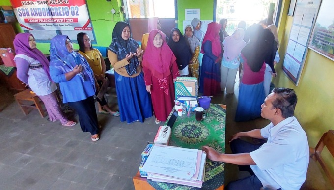 PROTES: Wali murid menyampaikan keberatan secara langsung di depan Kepala SDN Andongrejo 02. Mereka meminta dua guru yang dimutasi segera dikembalikan. (Jumai/Radar Jember)