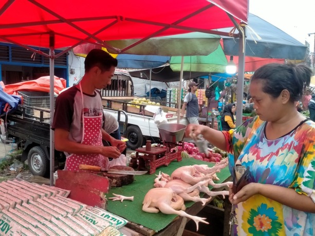 JUAL BELI: Para pedagang daging ayam sedang melayani pembeli di Pasar Tanjung.