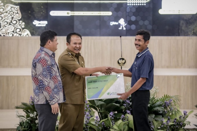 PRIORITAS: Bupati Jember Hendy Siswanto saat memberikan BPJS Ketenagakerjaan kepada salah satu nelayan di Jember.