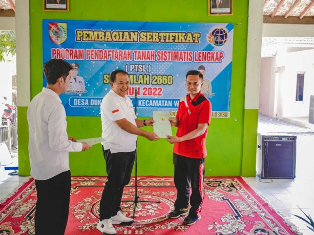 BAGIKAN: Bupati Jember Hendy Siswanto menyerahkan langsung sertifikat tanah program PTSL kepada warga Desa Dukuh Dempok, Kecamatan Wuluhan, Rabu (24/5).