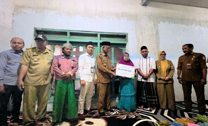 SALURKAN MANFAAT: Bupati Bondowoso Salwa Arifin didampingi kepala BPJamsostek Bondowoso Hadi Susanto, menyerahkan santunan kepada keluarga guru ngaji di rumah duka di Desa Gebang, Kecamatan Tenggarang, Selasa (9/5) kemarin.
