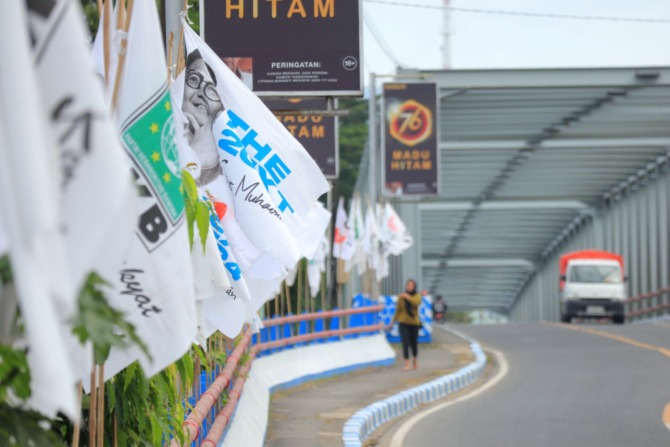 Gegap gempita pesta demokrasi begitu terasa jika melintasi Jembatan Arjowinangun, Pacitan Kota. Sisi kanan dan kiri jembatan tersebut penuh dengan bendera partai politik (parpol).