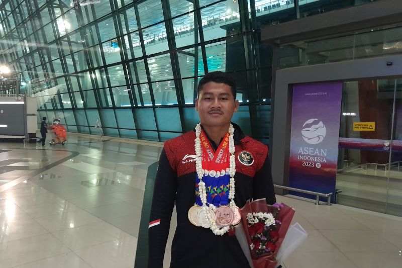 Atlet dayung Indonesia Rudiansyah memamerkan perolehan medali saat berada di terminal tiga bandara Soekarno-Hatta, Tangerang, Kamis.