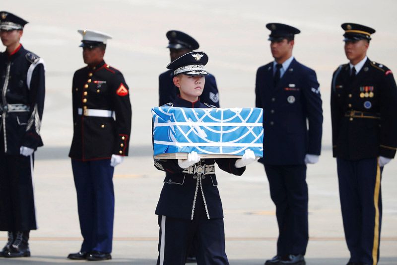 Seorang prajurit membawa sebuah peti berisi sisa jenazah prajurit Amerika Serikat yang tewas saat Perang Korea dalam sebuah upacara di Pangkalan Udara Osan di Pyeongtaek, Korea Selatan, Jumat (27/7/2018).
