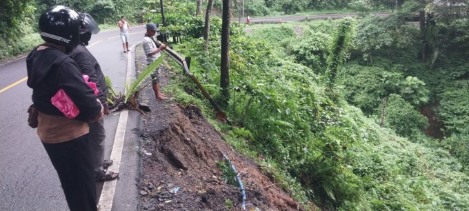 BELUM DIEVAKUASI: Pengguna jalan yang melintas masih penasaran dengan bangkai truk Fuso yang mengalami kecelakaan di Jalur Gumitir, Desa Sidomulyo, Kecamatan Silo, Kamis (11/5).