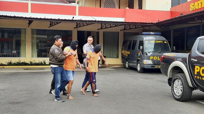 DIGIRING: Dua pelaku (baju oranye) spesialis pembobol rumah saat digiring oleh anggota kepolisian Polres Jember.