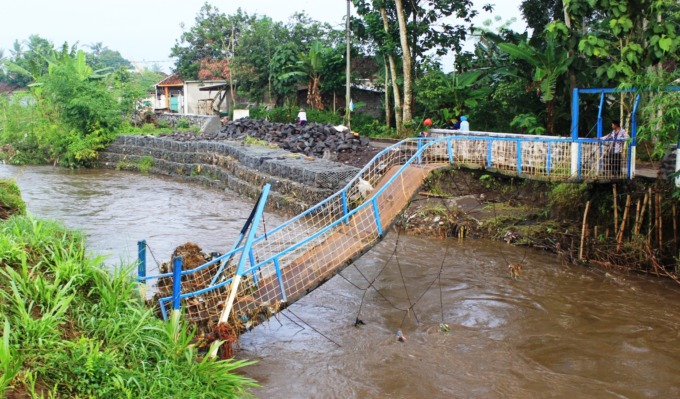 MELENGKUNG: Kondisi jembatan alternatif di Dusun Biting Satu, Desa Kutorenon, Kecamatan Sukodono, Lumajang yang ambruk, Jumat (5/5) dini hari. (FOTO: Atieqson Mar Iqbal/Rame)