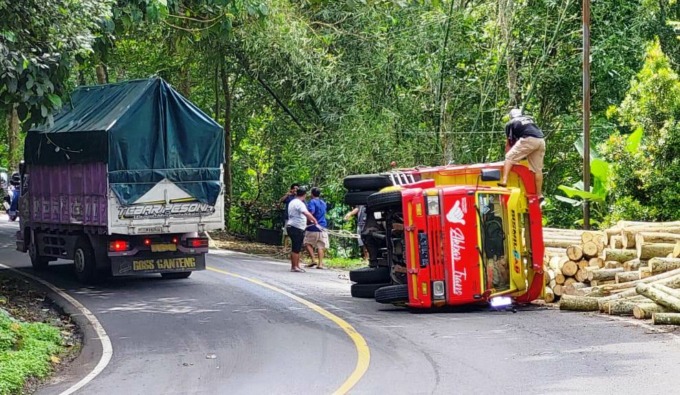 TERGULING: Kondisi truk pengangkut kayu sengon yang mengalami kecelakaan di jalur Gumitir, Jumat (12/5) siang.