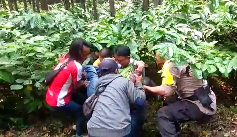 MENINGGAL: Anggota Polsek Silo dibantu warga dan Relawan Gumitir mengevakuasi jasad korban yang ditemukan di bawah kebun kopi. (Polsek Silo untuk Radar Jember)