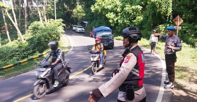 TUTUP JALUR: Petugas menghentikan kendaraan yang bakal melintas di jalur Gumitir. Selama proses evakuasi badan truk dari jurang berjalan, jalur yang menghubungkan Jember-Banyuwangi itu ditutup total. (Jumai/Radar Jember)