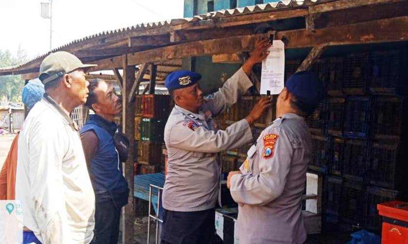 PERINGATAN: Personel Satpolair Polres Jember memasang pamflet imbauan di kawasan TPI Puger, menyusul agenda Latihan menembak di perairan Pandanwangi, Lumajang. (Satpolair untuk Radar Jember)