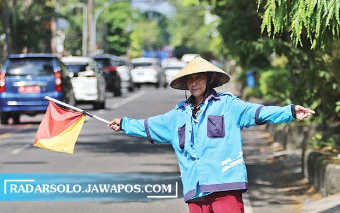 Sri Suharto tampak sedang sibuk mengatur mobil akan parkir di kawasan Mangkubumen, Banjarsari, Rabu (24/5).