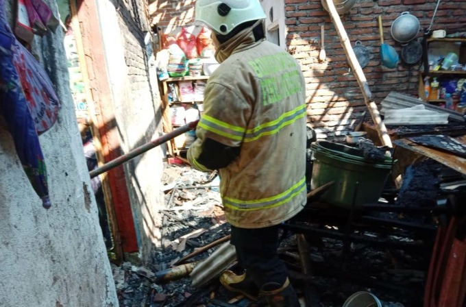 DIPADAMKAN: Tim Damkar Bondowoso memadamkan api yang membakar rumah warga di Desa Maskuning Kulon, Kecamatan Pujer, Rabu (14/6) pagi. (Satpol PP Bondowoso untuk Radar Ijen)