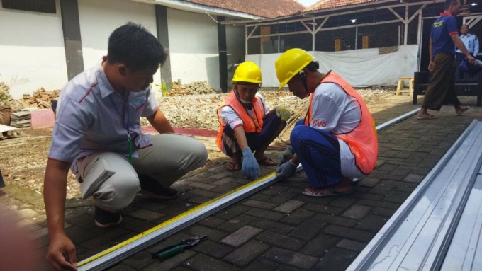 TRANSFER ILMU: Guru konstruksi bangunan SMKN 2 Jember (kiri) saat memberikan pelatihan tentang konstruksi baja ringan kepada warga binaan Lapas Kelas II A Jember, kemarin (5/6). (ILHAM WAHYUDI/RADAR JEMBER)