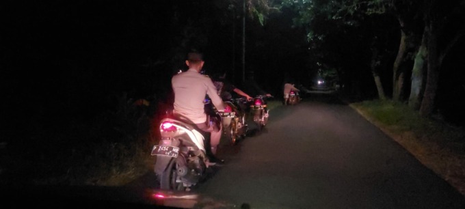 BELUM JERA: Anggota Polsek Sumberbaru memantau pelaku balap liar yang mendorong motornya. Setidaknya ada 18 unit motor berbagai jenis yang diamankan dalam balap liar di Jalan Nasional Jember–Lumajang.