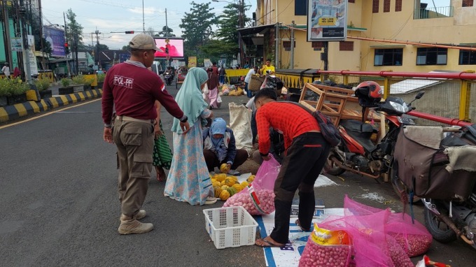 KURANG SADAR: Salah satu petugas Satpol PP Jember ketika menegur PKL yang berjualan di Geladak Kembar, Kepatihan, Kaliwates.
