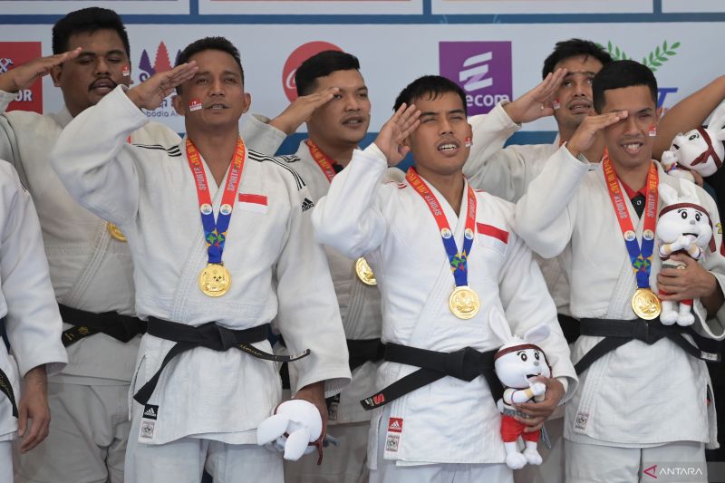 Tim beregu judoka tunanetra Indonesia yang mengenakan medali emas memberi hormat ke bendera Merah Putih saat upacara penghargaan pemenang usai final judo tunanetra putra beregu ASEAN Para Games 2023 di Youth Federation Hall, Phnom Penh, Kamboja, Selasa (6