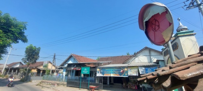 RUSAK PARAH: Kondisi convex mirror atau kaca cembung di jalan tikungan rusak parah. Kaca yang berada di jalan Wirowongso, Ajung, itu kini belum diperbaiki atau diganti. (JUMAI/RADAR JEMBER)
