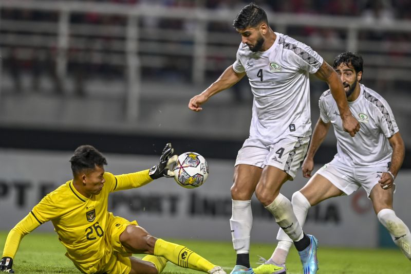 Penjaga gawang Timnas Indonesia Esyahrul Trisna Fadillah (kiri) menghalau tendangan pemain Timnas Palestina Yaser Hamed (kanan) pada pertandingan FIFA Matchday di Stadion Gelora Bung Tomo, Surabaya, Jawa Timur, Rabu (14/6/2023). Dalam pertandingan tersebu