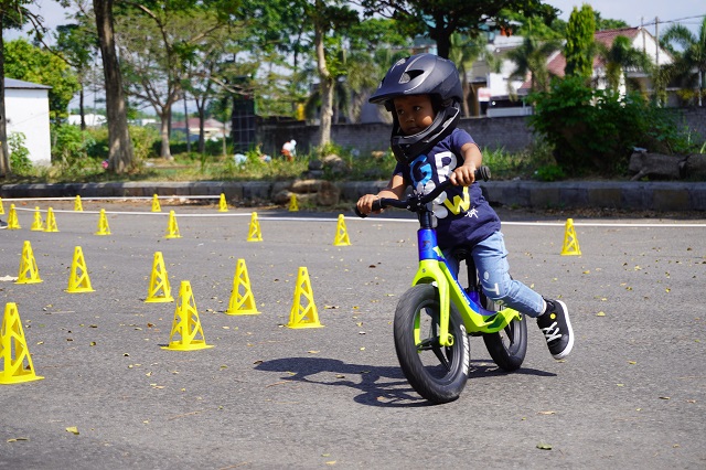Tampak anak-anak bermain dengan menaiki push bike mengitari jalur lintasan sirkuit buatan. Foto: Habibah A. Muktiara/JPRK)