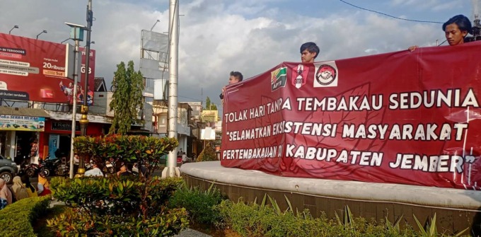 TURUN JALAN: Aksi mahasiswa dan petani yang menyuarakan persoalan pertembakauan yang selama ini dianggap sangat merugikan petani tembakau di bundaran DPRD Jember, Sabtu (3/6). (Maulana/Radar Jember)