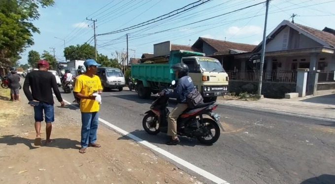 TIMBULKAN KORBAN: Warga mengumpulkan potongan tubuh korban tabrak lari di jalan jurusan Jember-Banyuwangi Desa Kertosari, Kecamatan Pakusari, Senin (5/6) pagi.