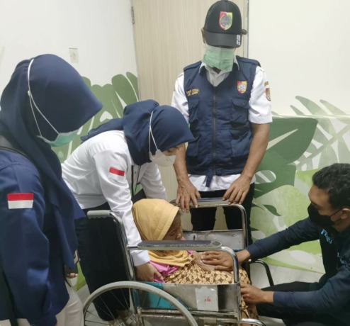 BERI PERAWATAN: Tim Reaksi Cepat Dinsos Jember bersiap membawa Sati ke RSD dr Soebandi untuk pemeriksaan benjolan di wajah. (Dinsos Jember untuk Radar Jember)