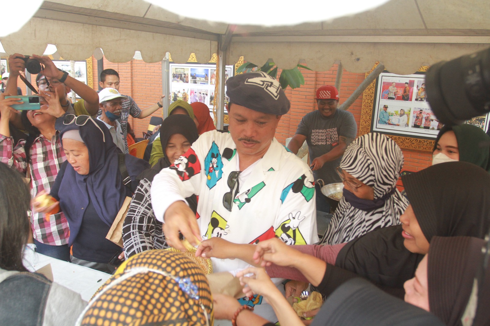 MENGHIBUR: Wali Kota Madiun Maidi menggoreng tahu-tempe di salah satu stand UMKM yang ada di Pasar Rakyat HUT ke-105 Kota Madiun, kemarin (20/6). (BAGAS BIMANTARA/RADAR MADIUN)