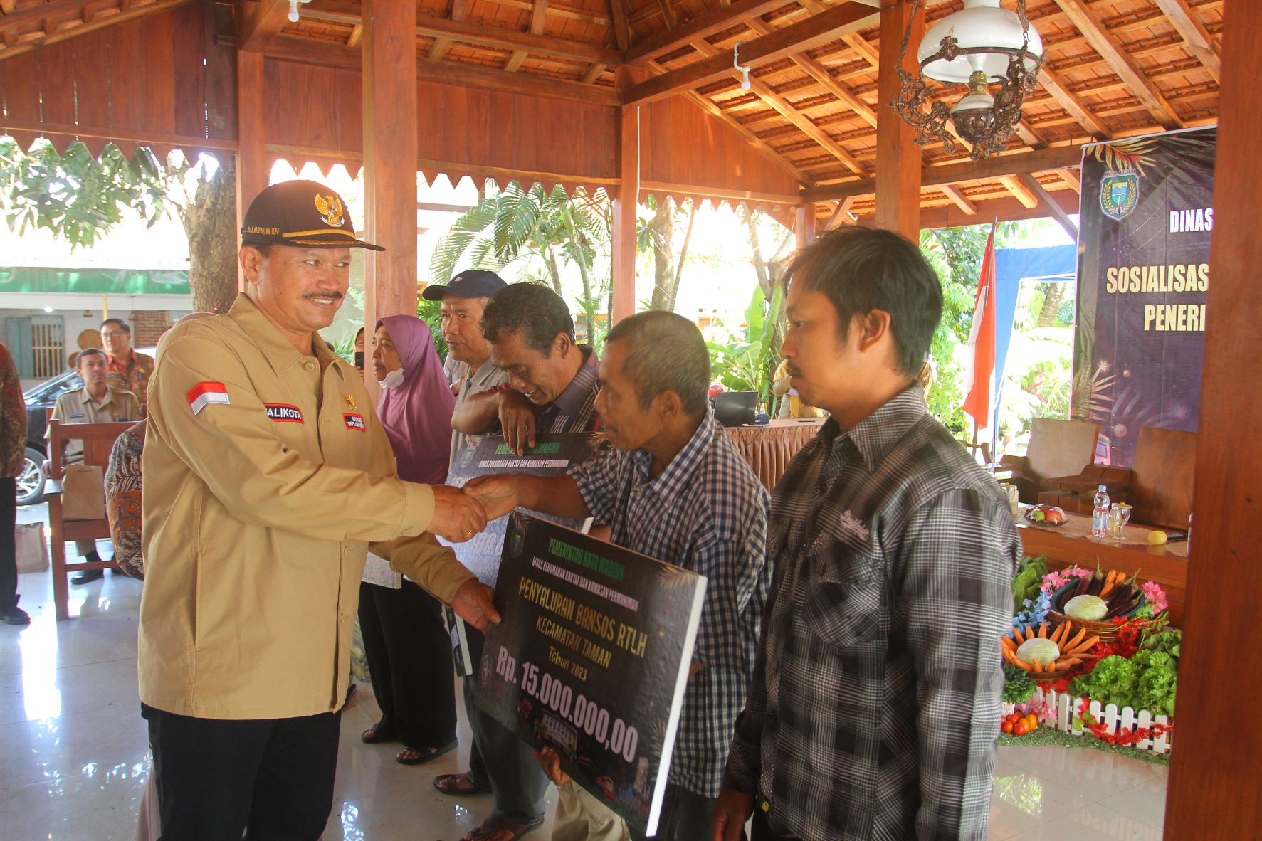 PROGRAM: Wali Kota Maidi memberikan bantuan RTLH secara simbolis kepada keluarga penerima manfaat (KPM) di Lapak Obor kemarin (27/6). (BAGAS BIMANTARA/RADAR MADIUN)