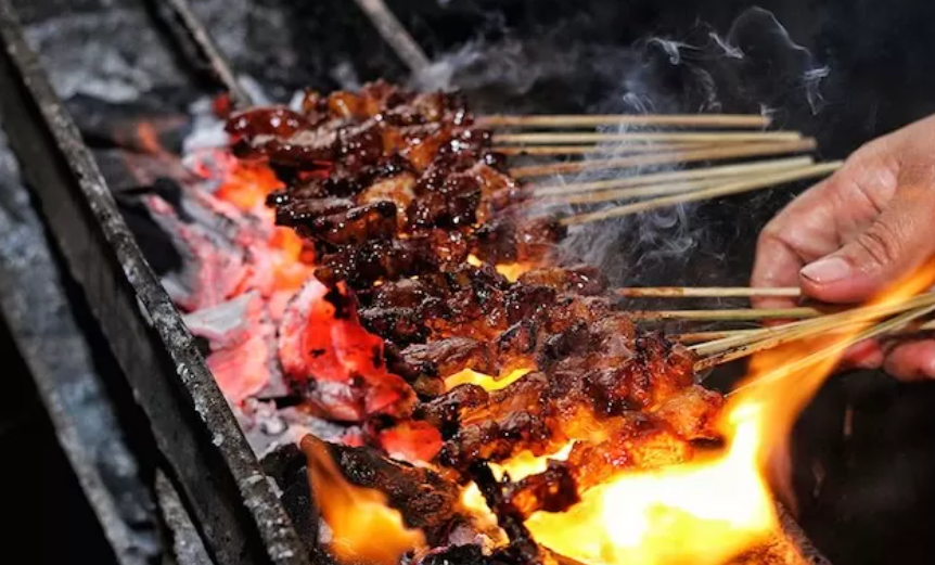 LEZAT: Ilustrasi sate yang sedang dibakar. (JAWAPOS.COM)