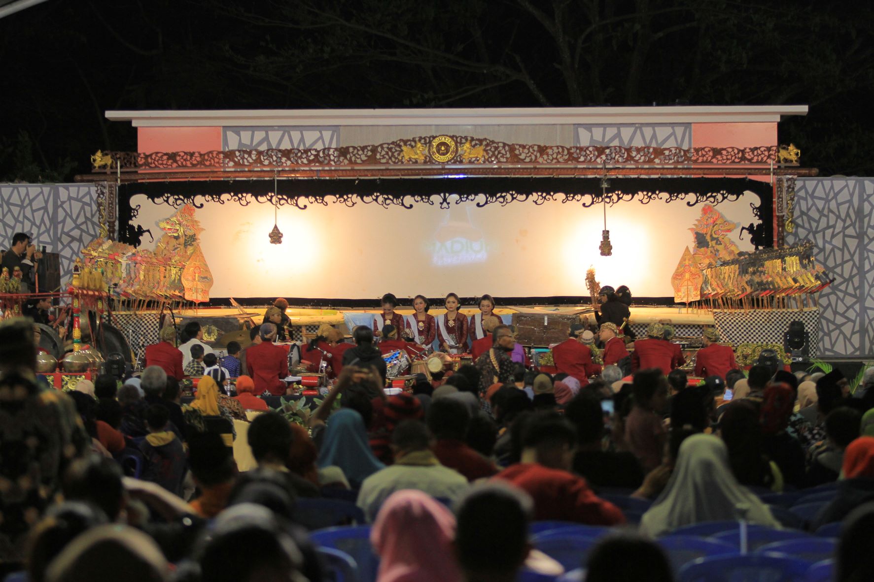 LESTARIKAN SENI TRADISIONAL: Warga menikmati pagelaran wayang kulit di Lapangan Pelti. (BAGAS BIMANTARA/RADAR MADIUN)