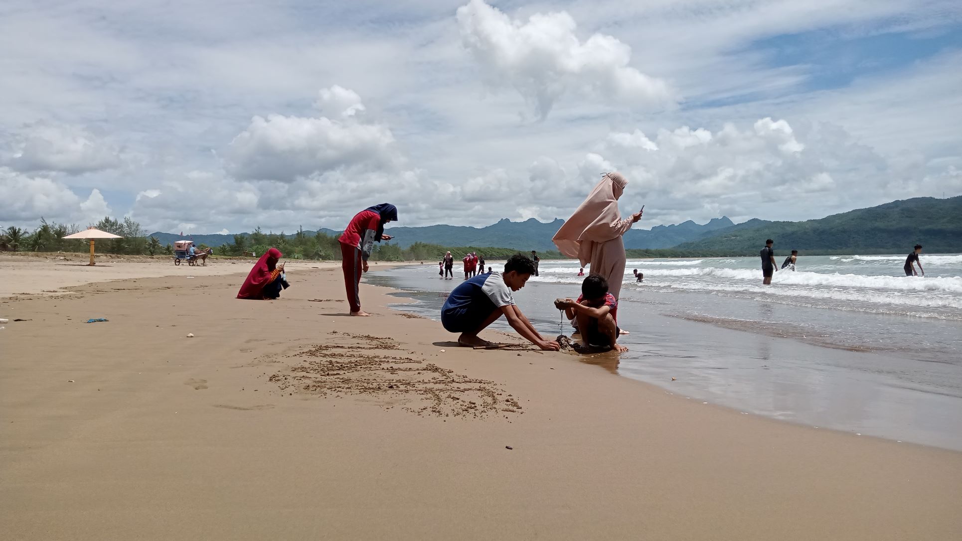 WASPADA: Sejumlah wisatawan bermain air di Pantai Teleng Ria. BPBD Pacitan mengingatkan musim ubur-ubur telah tiba. (NUR CAHYONO/RADAR PACITAN)