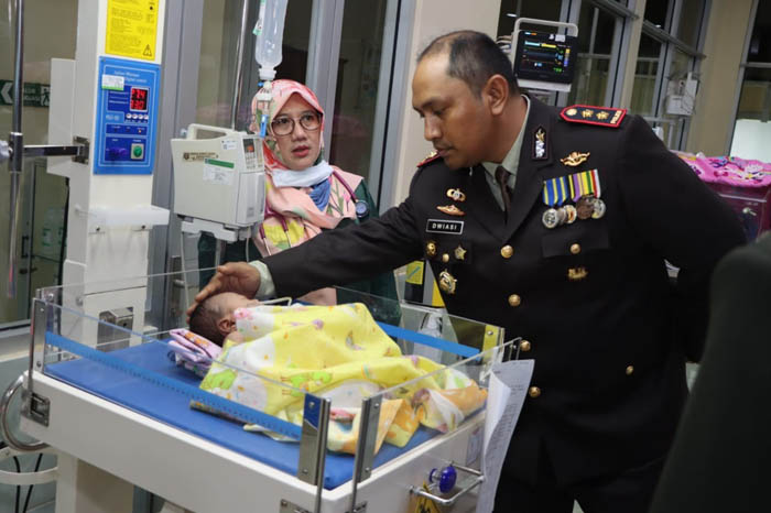KASIHAN: Kapolres Ngawi AKBP Dwiasi Wiyatputera menjenguk bayi perempuan yang diduga dibuang di pinggir jalan Desa Kandangan, Ngawi. (ASEP SYAEFUL BACHRI/JAWA POS RADAR NGAWI)