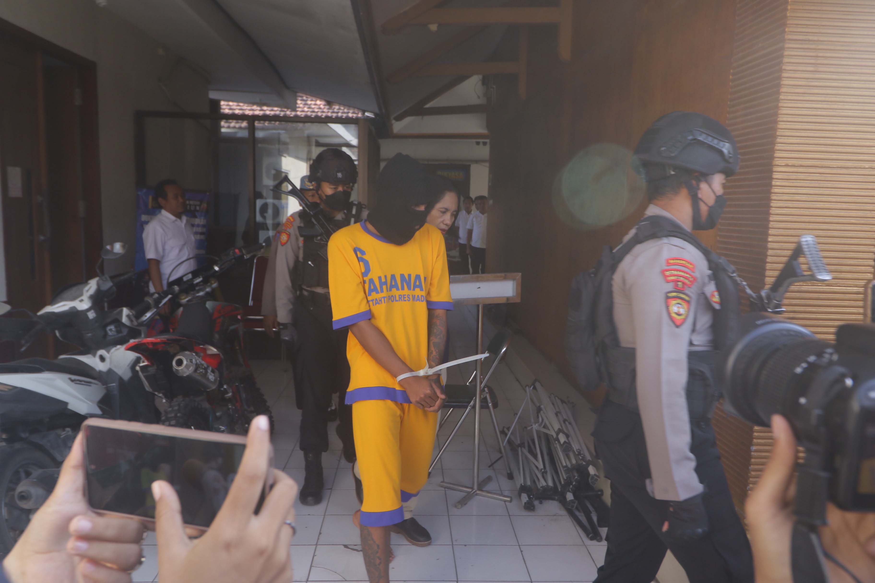 BERBAJU ORANYE: Iqbal Riskia, pembunuh Miftachul Barokah, digelandang petugas menjelang rilis pers di Mapolres Madiun kemarin. (R. BAGUS RAHADI/JAWA POS RADAR MADIUN)