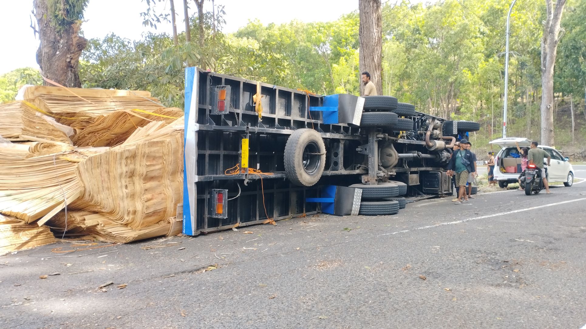BERKELAK-KELOK: Posisi truk bermuatan kayu lapis yang terguling di Jalan Solo-Pacitan, ruas Dadapan, Pringkuku, sebelum dievakuasi kemarin (14/7). (NUR CAHYONO/RADAR PACITAN)