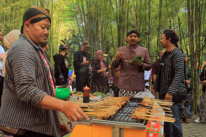 NOSTALGIA: Bupati Ngawi Ony Anwar Harsono mencicipi salah satu jajanan di Pasar Jadul Ahad Legi. (BAGAS BIMANTARA/RADAR MADIUN)