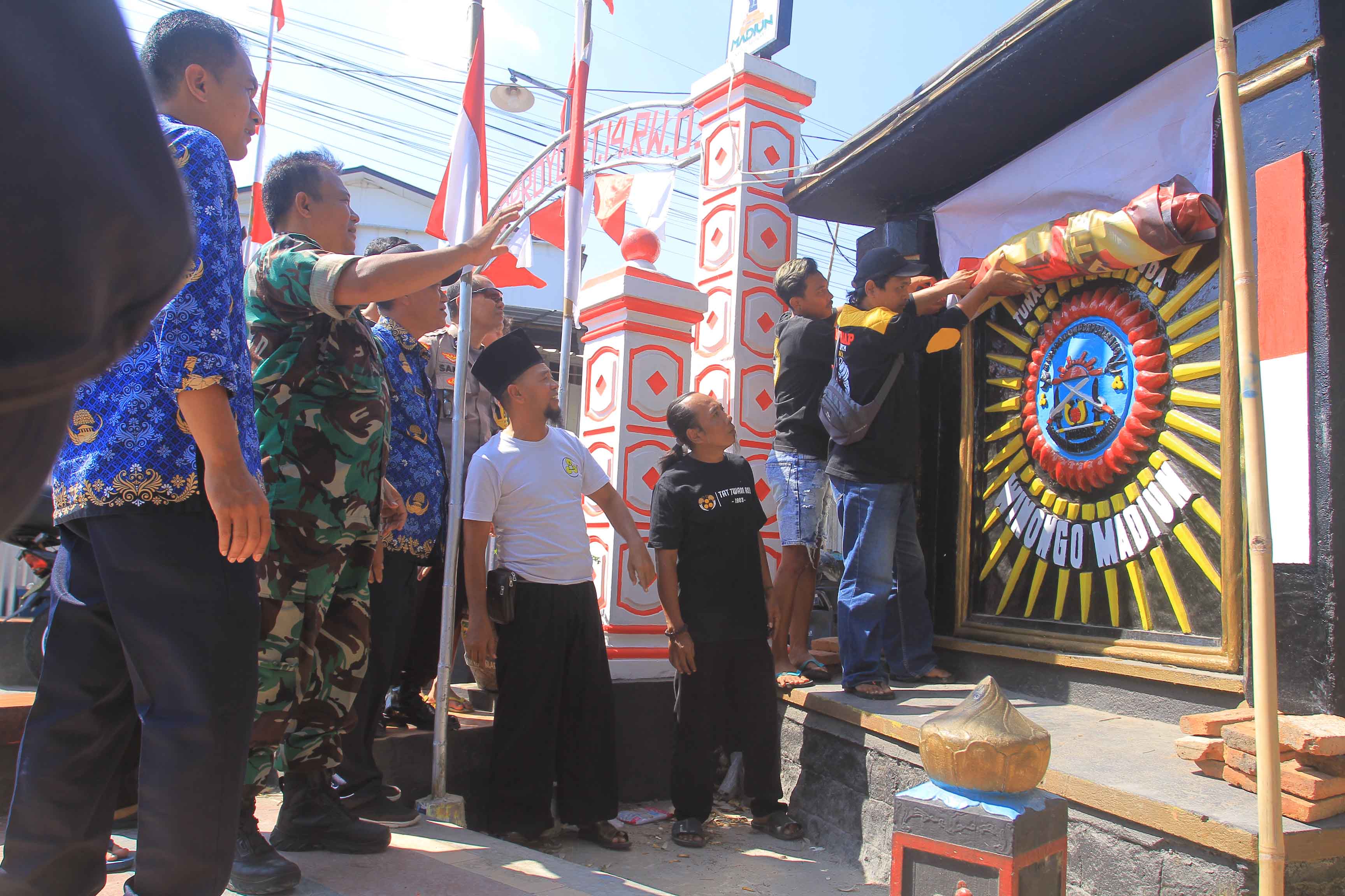AMAN: Masyarakat dan anggota perguruan pencak silat menutup masing-masing tugu yang ada di Jalan Mayjend Sungkono kemarin (17/7). (BAGAS BIMANTARA/RADAR MADIUN)