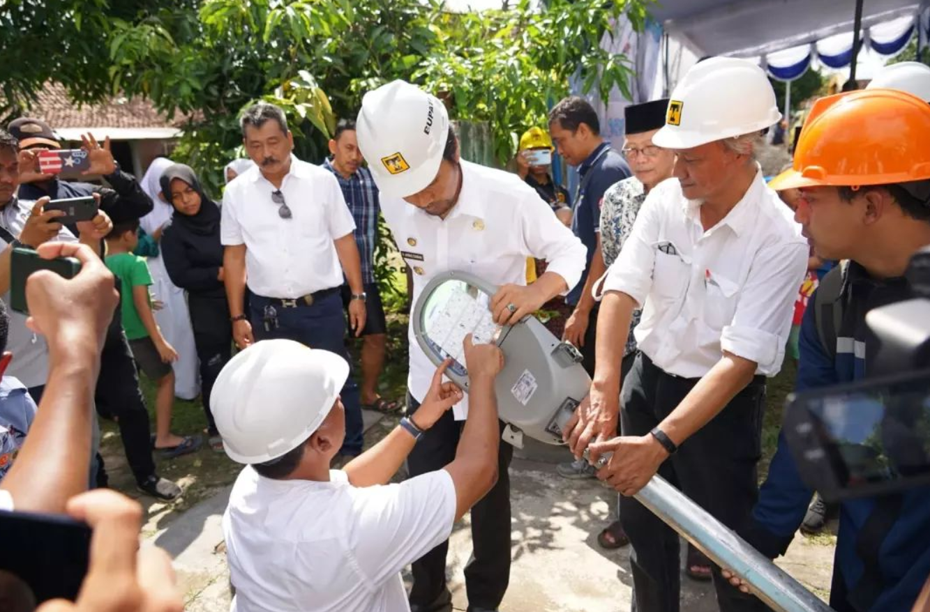 SIMBOLIS: Bupati Madiun Ahmad Dawami bersama perwakilan PT Tri Tunggal Madiun Terang memasang tiang APJ perdana. (ISTIMEWA)