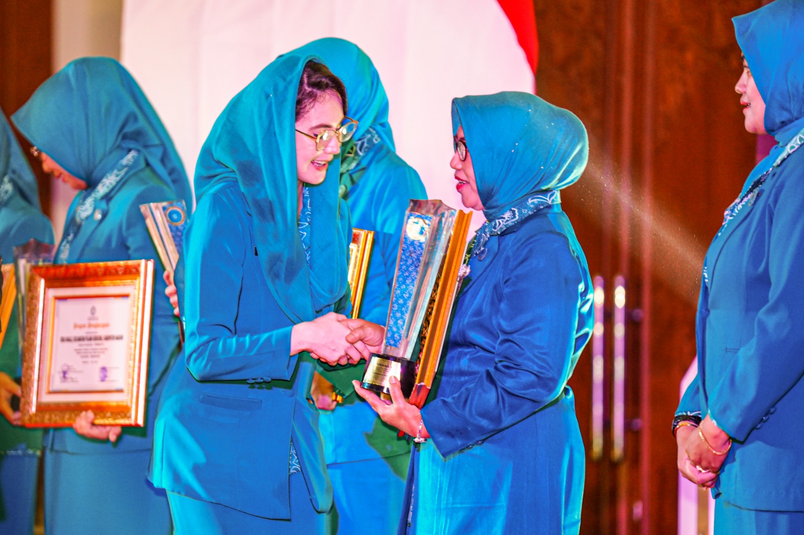 YANG TERBAIK: Ketua TP PKK Kota Madiun Yuni Setyawati Maidi menerima piagam dari Ketua TP PKK Provinsi Jatim Arumi Bachsin pada Minggu (16/7) malam.&nbsp;(DISKOMINFO UNTUK RADAR MADIUN)