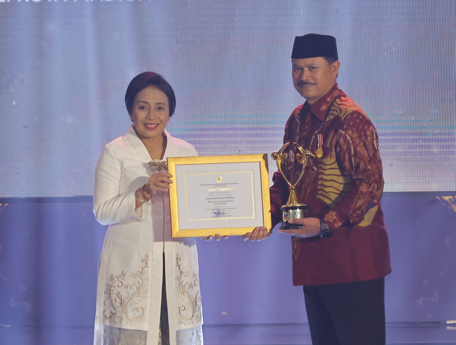 RAMAH ANAK: Wali Kota Madiun Maidi menerima Penghargaan Kota Layak Anak (KLA) predikat utama dari Menteri PPPA Bintang Puspayoga di Hotel Padma Kota Semarang, Sabtu lalu (22/7). (WS HENDRO DISKOMINFO)