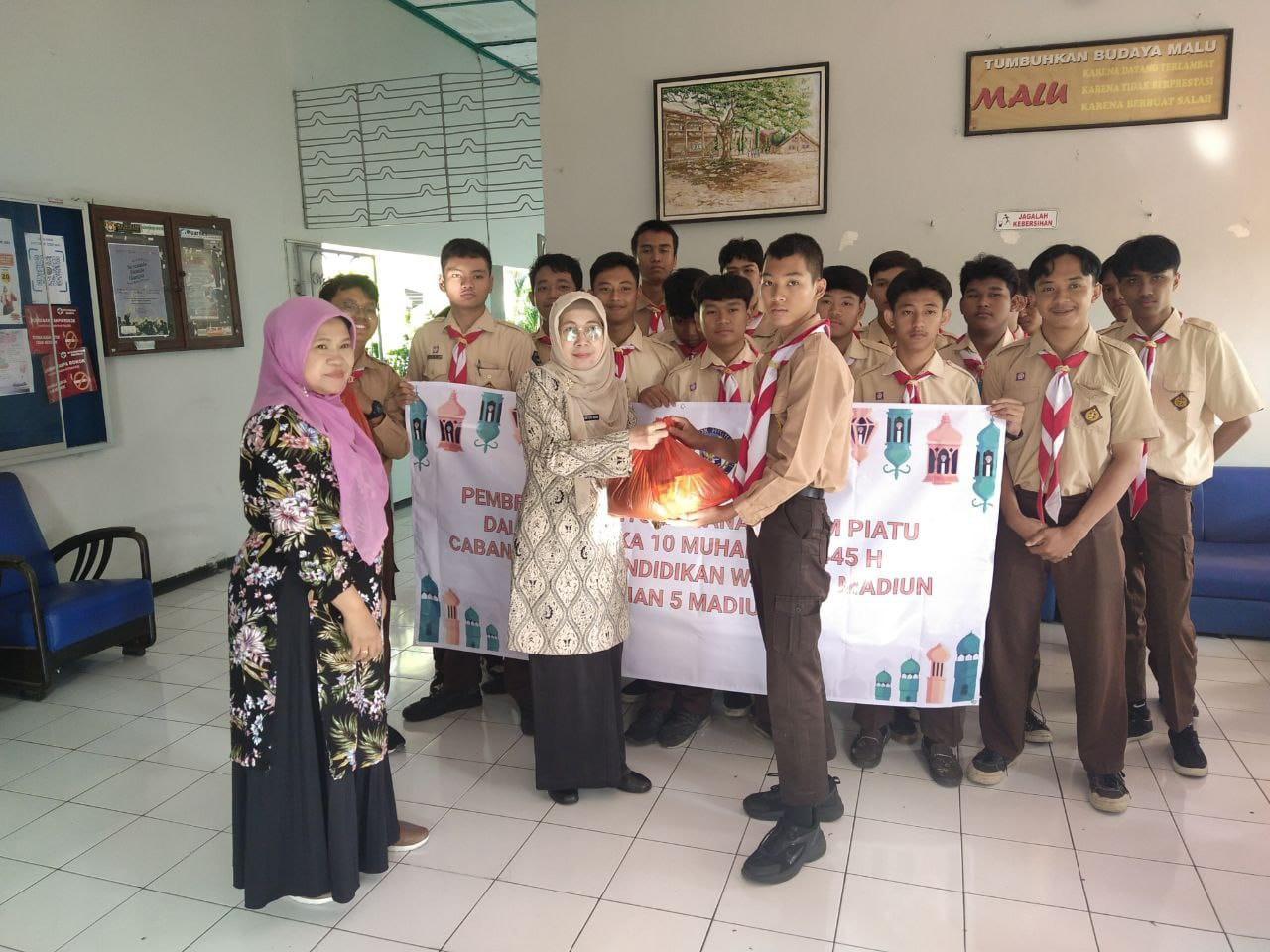 PEDULI SESAMA: Kepala SMAN 5 Madiun Wahyu Astuti Budi saat membagikan sembako kepada siswa yang kurang mampu. (ABRIANTO WIBOWO/RADAR MADIUN)