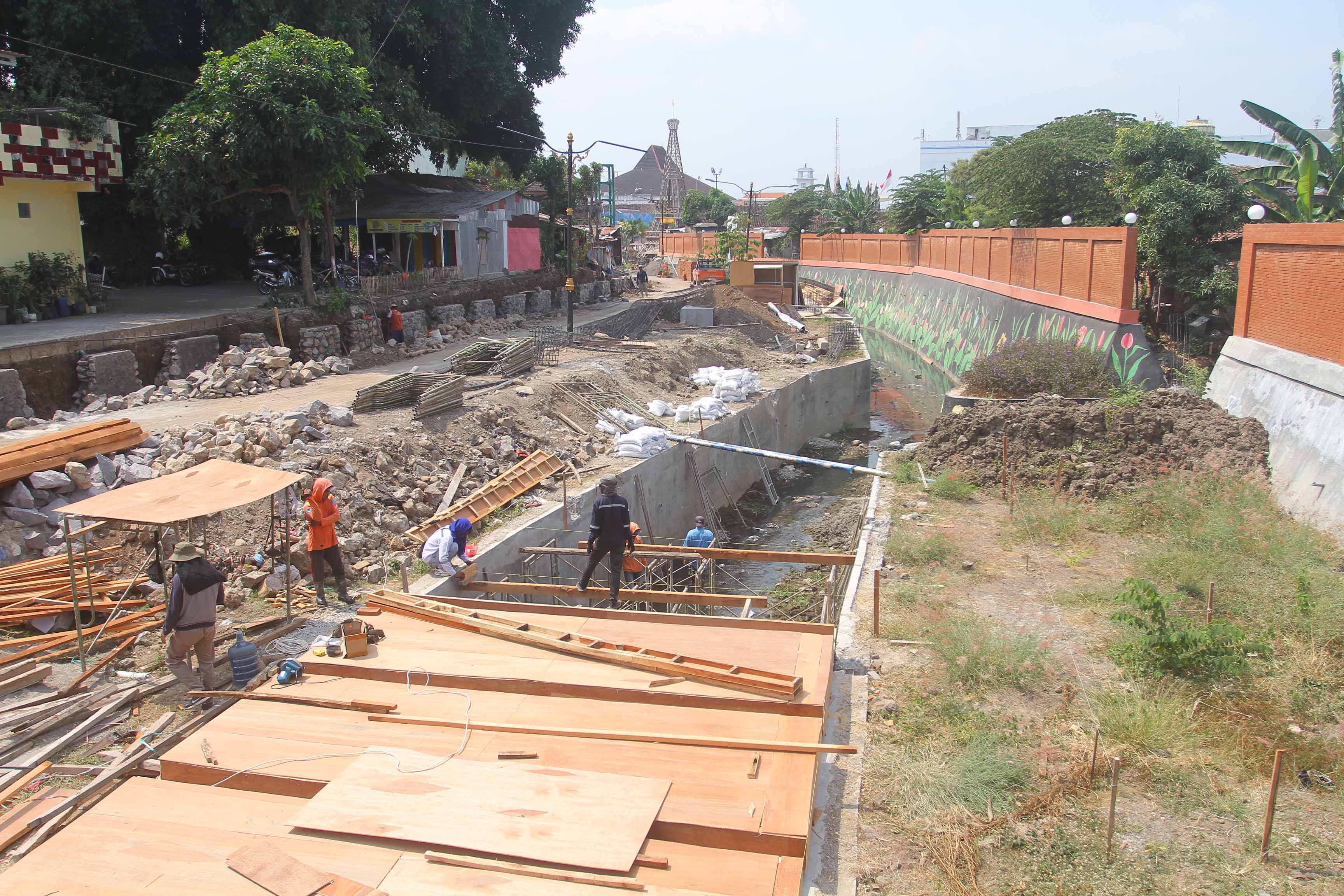 PROBLEMATIK: Normalisasi sekaligus peningkatan saluran air di Jalan Pandan masuk kawasan Sumber Umis dikerjakan untuk penanganan masalah banjir kota. (BAGAS BIMANTARA/RADAR MADIUN)