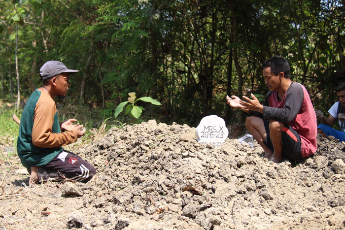 PEMAKAMAN LAYAK: Tim Disperkim Ngawi melafalkan doa untuk Mrs X yang diduga korban pembunuhan, kemarin. Jasadnya dimakamkan di TPK Desa Selopuro, Pitu. (ASEP SYAEFUL BACHRI/JAWA POS RADAR NGAWI)