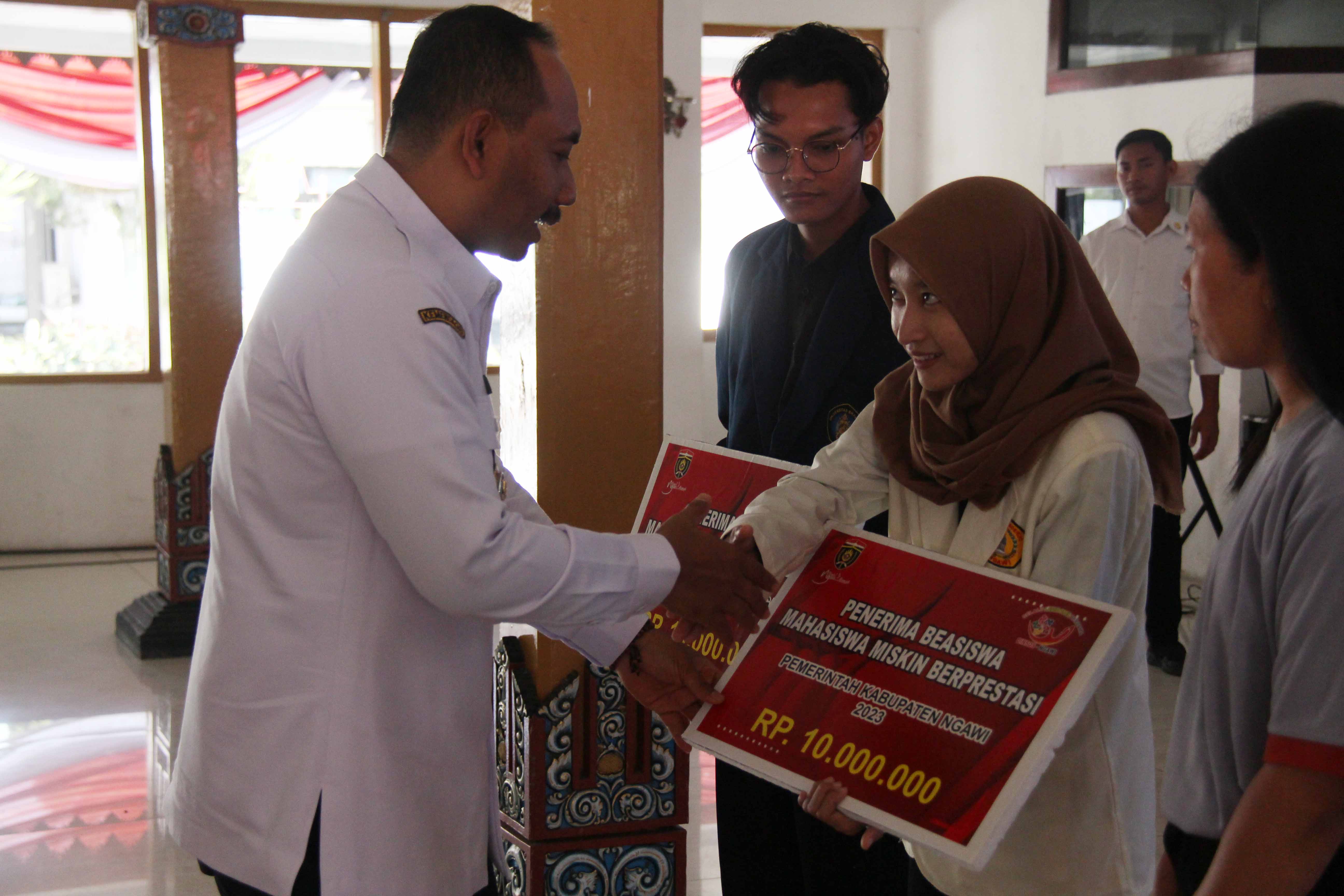 PENGENTASAN KEMISKINAN: Bupati Ngawi Ony Anwar Harsono memberikan beasiswa mahasiswa miskin, Rabu (2/8).&nbsp;(ASEP SYAEFUL BACHRI/JAWA POS RADAR NGAWI)