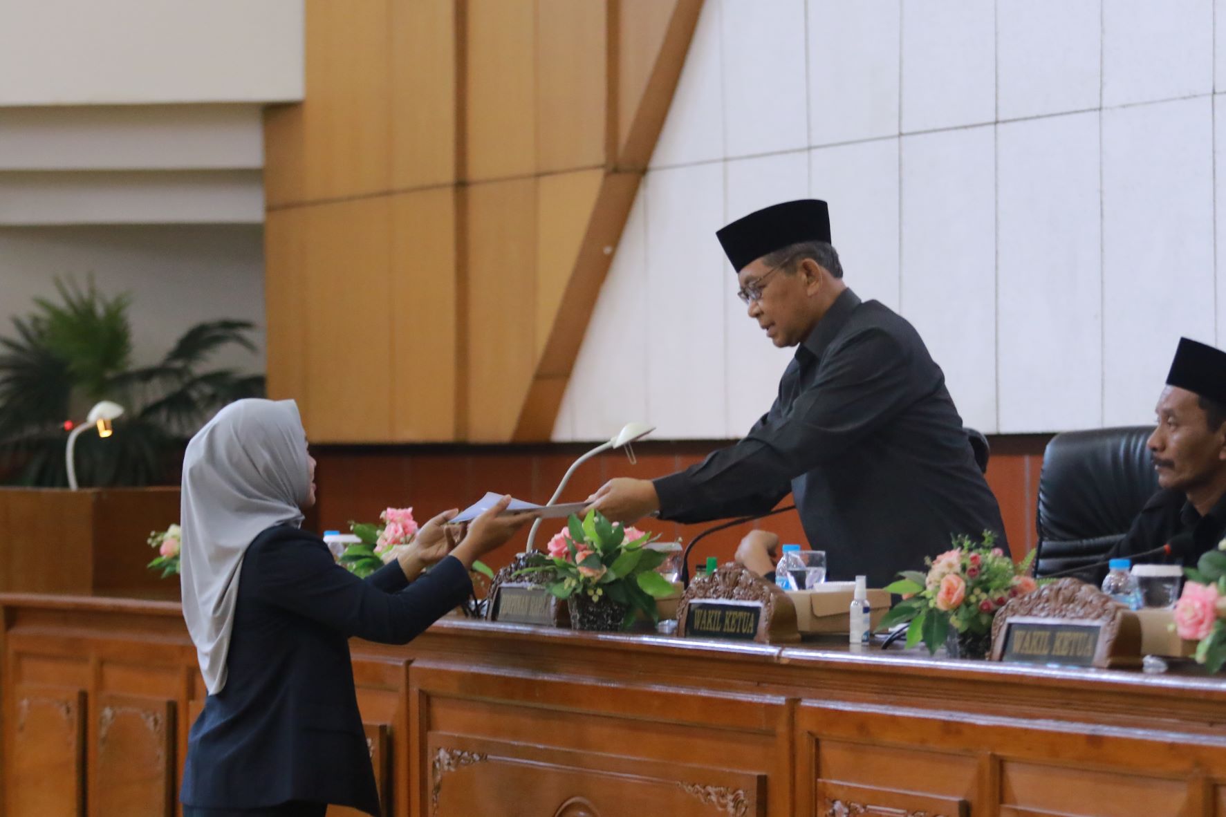 RESMI: Leni Nurjanah menyerahkan laporan pandangan umum fraksi PKB ke Wakil Ketua DPRD Kabupaten Madiun Slamet Rijadi selaku pimpinan rapat.&nbsp;(R. BAGUS RAHADI/RADAR CARUBAN)