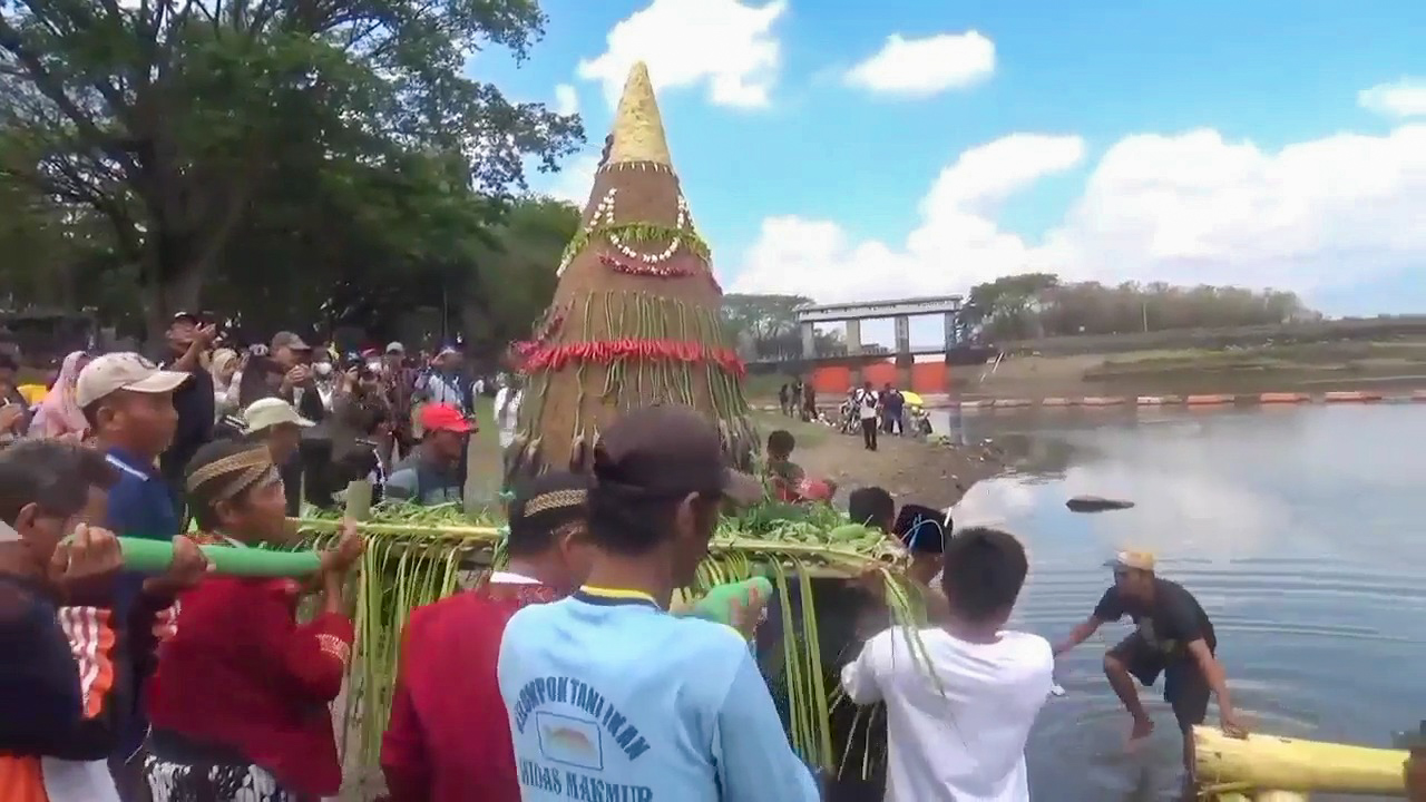 DIURI-URI: Warga bersama Perum Jasa Tirta menggelar kirab Buceng Bogo Mulyo Larung Sesaji di Waduk Bening, Desa Pajaran, Kecamatan Saradan, kemarin (6/8). (DIAN RAHAYU/RADAR CARUBAN)