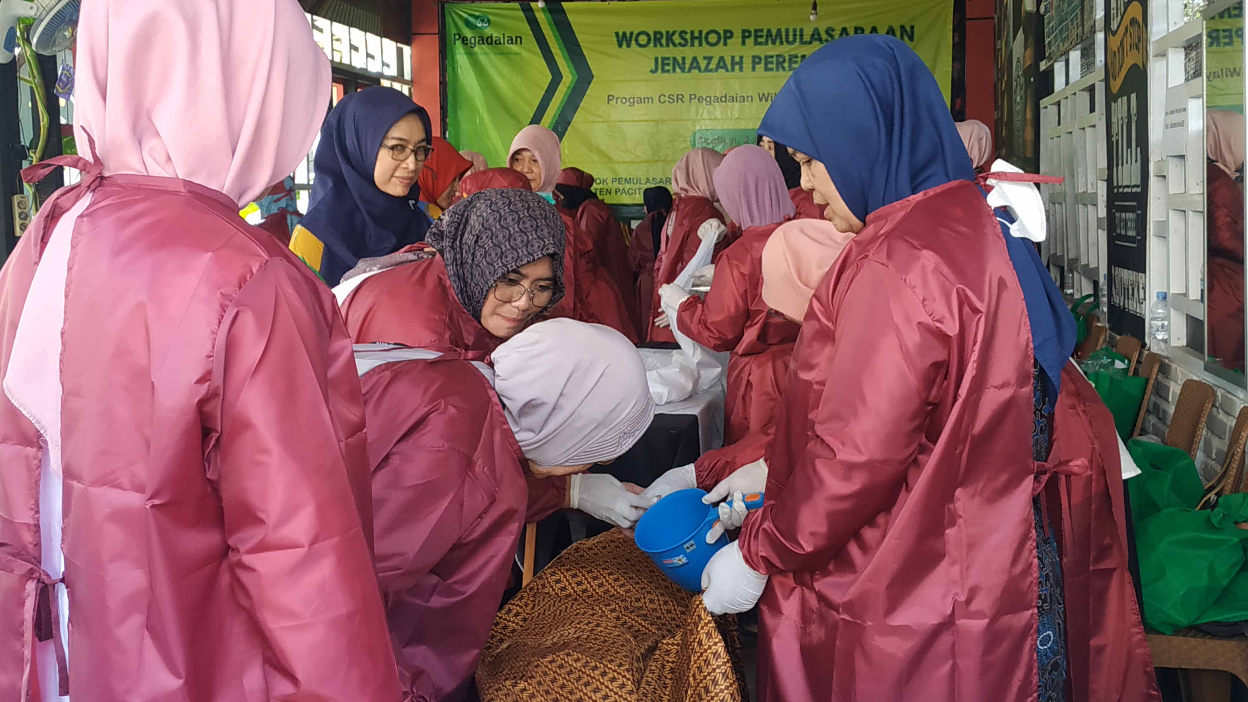 SESUAI SYARIAT: Para relawan perempuan memeragakan cara memulasar jenazah muslimah dengan media boneka kemarin (11/8).&nbsp;(NUR CAHYONO/RADAR PACITAN)