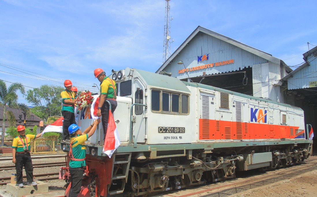 KERETA API: Petugas PT KAI Daop 7 Madiun bersama dengan anggota kelompok Pecel +63 menghias lokomotif CC 201 89 09 kemarin (17/8).&nbsp;(BAGAS BIMANTARA/RADAR MADIUN)