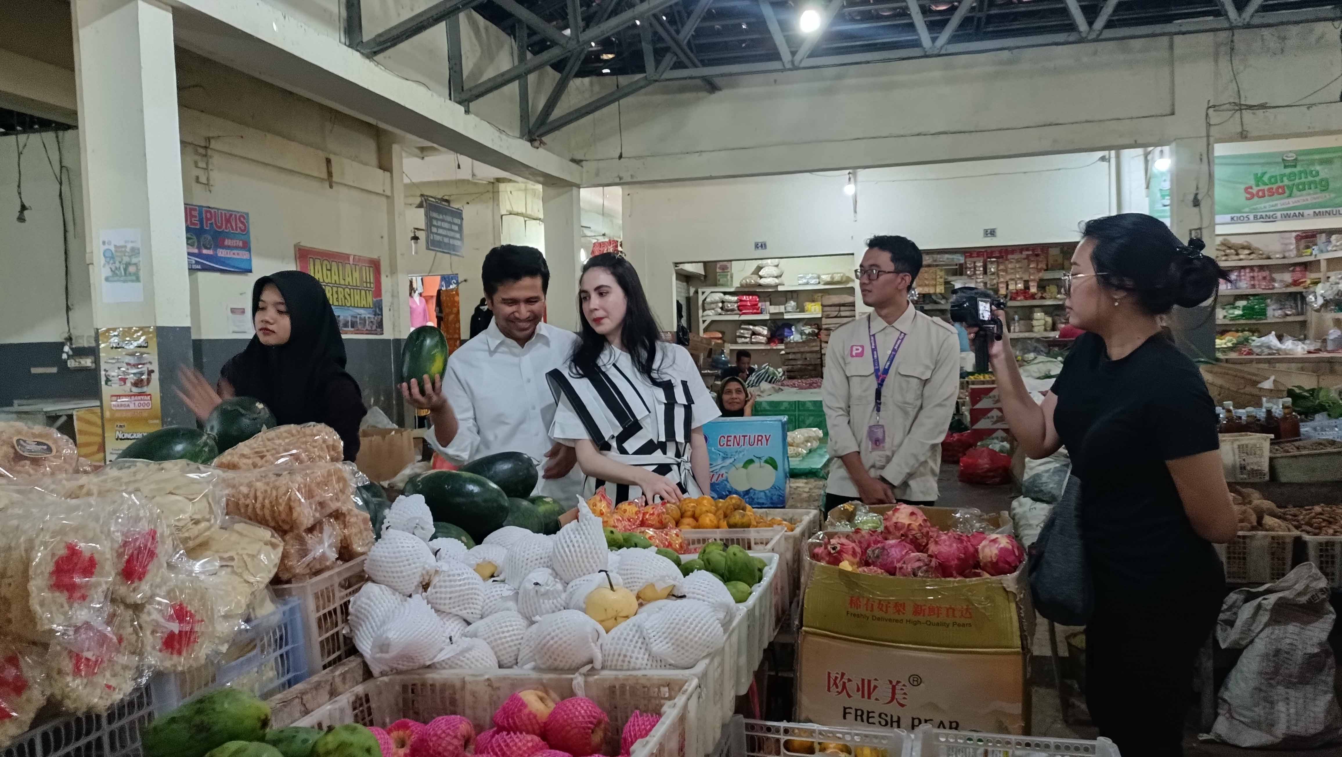 BLUSUKAN: Wagub Jatim Emil Elestianto Dardak dan istrinya Arumi Bachsin berbelanja sekaligus cek harga komoditas di Pasar Minulyo, Pacitan, kemarin (18/8).&nbsp;(NUR CAHYONO/RADAR PACITAN)