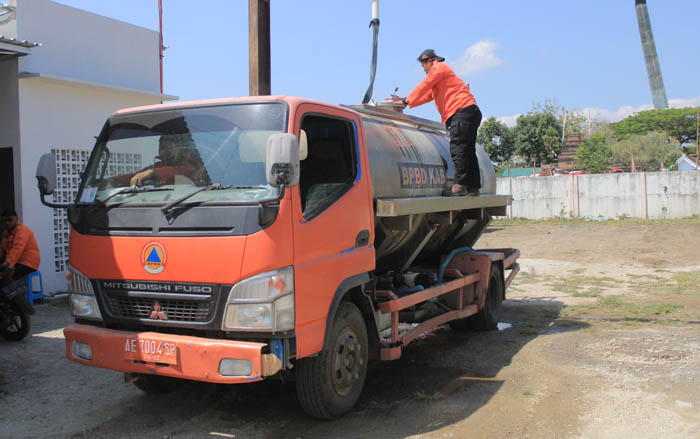 JAGA MATA AIR: Petugas BPBD menyiapkan dropping air bersih ke Desa Duri, Slahung. (AJI PUTRA/JAWA POS RADAR PONOROGO)